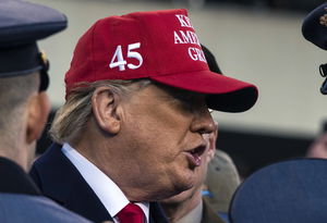 Donald Trump wearing a red baseball cap with the number 45 in white on the side.