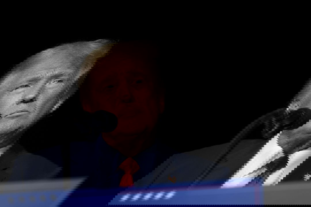 Donal Trump stands at a podium, looking angry